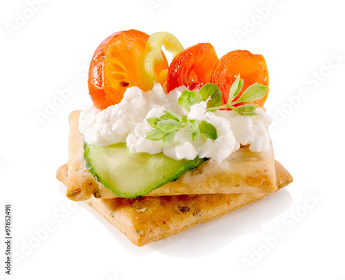 appetizer on crackers with cream cheese and vegetables close-up isolated on white background 