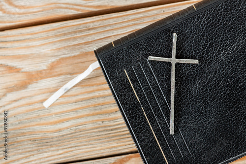 Silver christian cross on bible