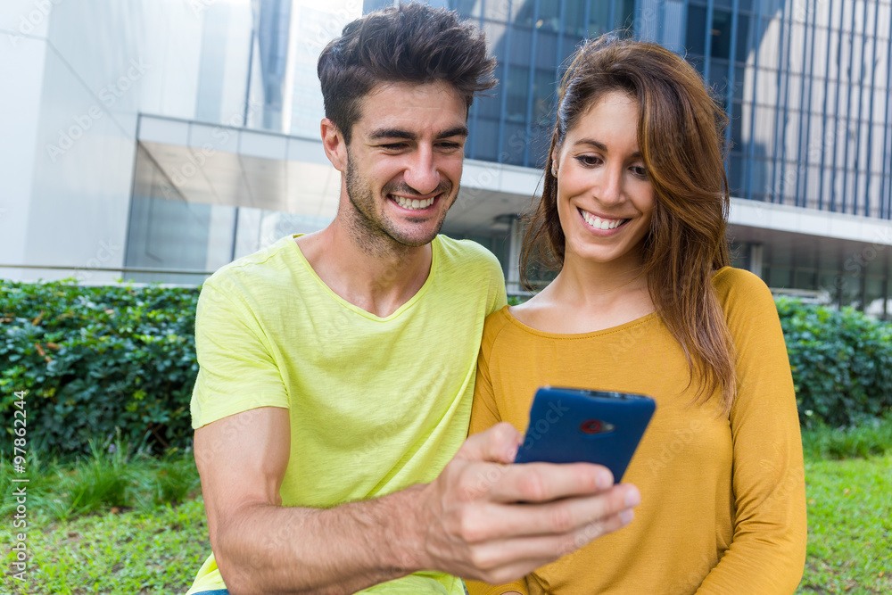 Caucasian couple look at the cellphone together Caucasian couple look at the cellphone together