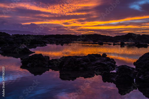Fotografering Sunset at Shark's Cove Beach with rocky shore