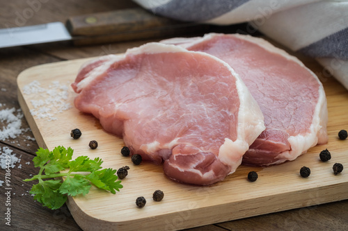 Raw pork meat sliced on wooden cutting board