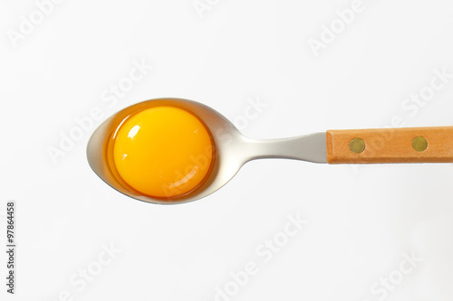 Raw egg yolk on spoon