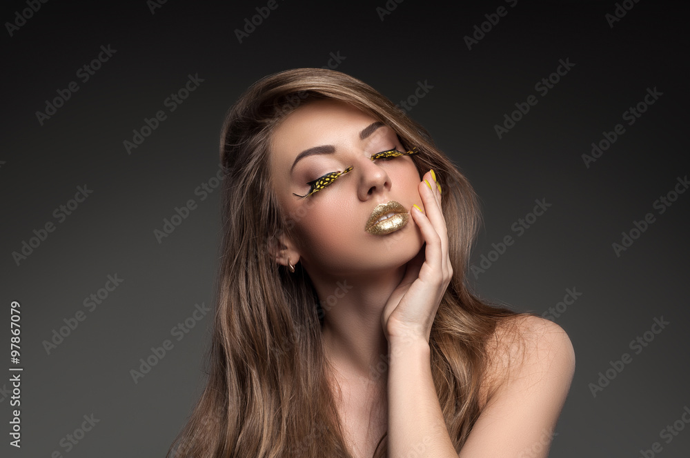 High fashion look, closeup beauty portrait of beautiful young woman model with bright makeup with perfect clean skin with colorful gold lips High fashion look, closeup beauty portrait of beautiful young woman model with bright makeup with perfect clean skin with colorful gold lips