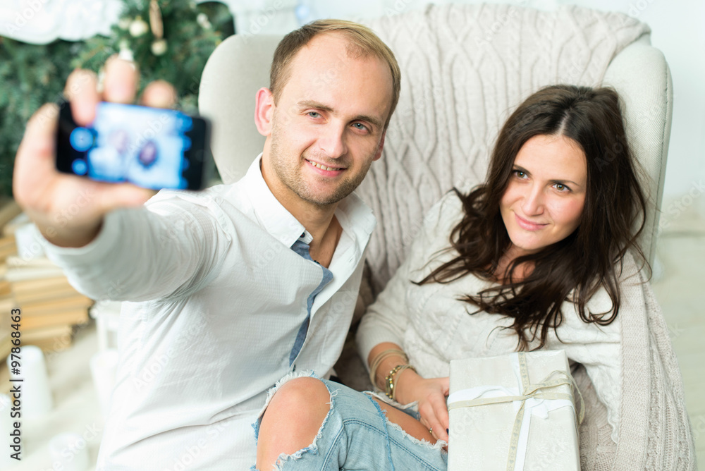 Fototapeta premium Christmas selfie. Couple in love is in festive Christmas decorat