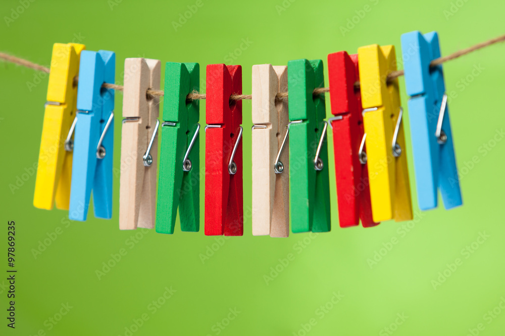 wooden clothespin hanging on rope.  colorful clothespins.