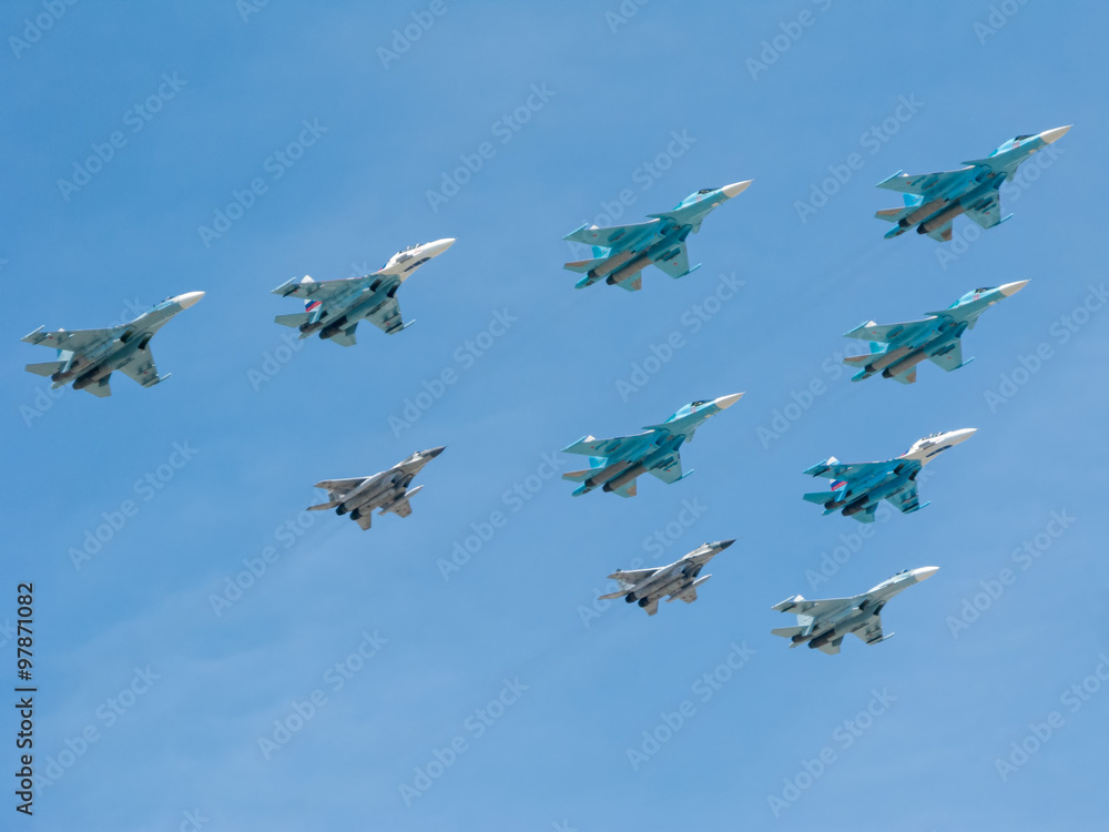 Su-34 (Fullback) fighter-bombers, 4 Su-27 (Flanker) supermaneuverable fighters and 2 Mikoyan MiG-29 (Fulcrum) jet-fighter aircrafts form in sky unique aerobatic triangle figure Tactical Wing. Su-34 (Fullback) fighter-bombers, 4 Su-27 (Flanker) supermaneuverable fighters and 2 Mikoyan MiG-29 (Fulcrum) jet-fighter aircrafts form in sky unique aerobatic triangle figure Tactical Wing.