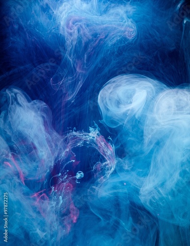 Smoky blue and pink ink in motion on water isolated on black