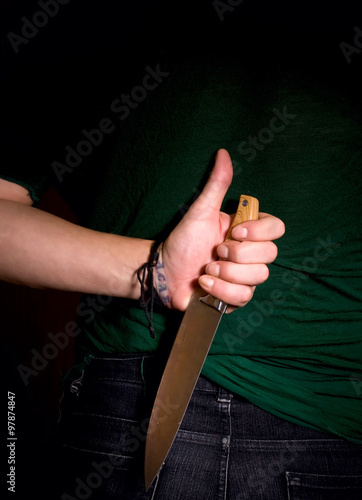 hand with knife behind his back