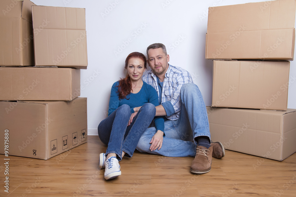 happy couple in their new home with cardboard boxes happy couple in their new home with cardboard boxes