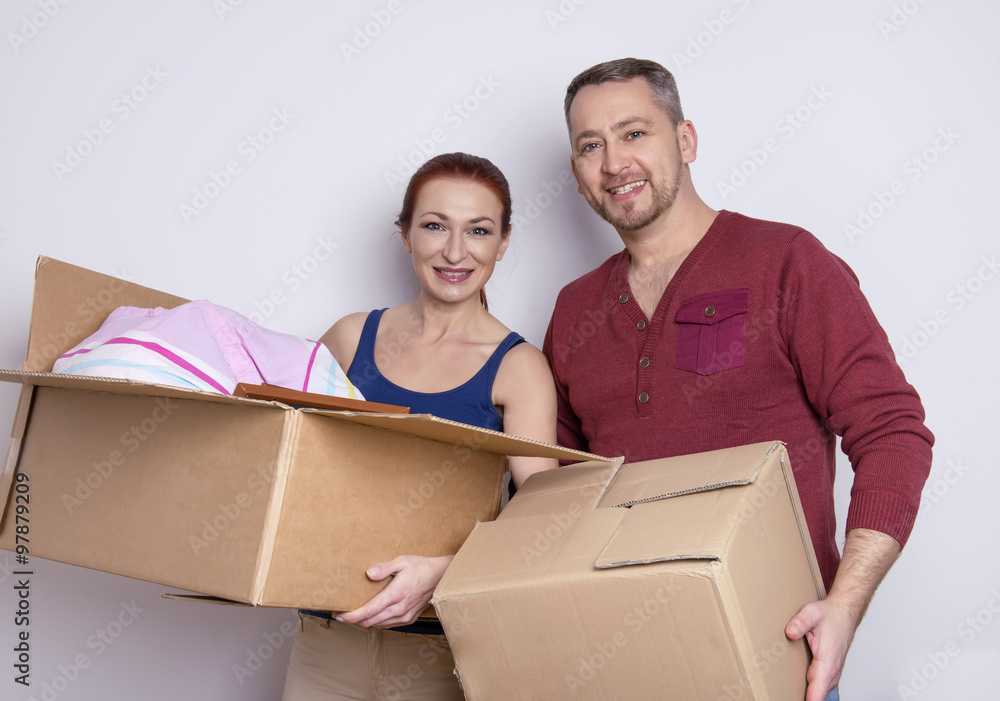 happy couple in their new home with cardboard boxes happy couple in their new home with cardboard boxes
