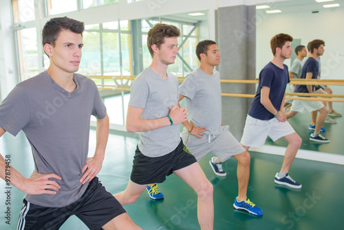Four young men exercising in gym