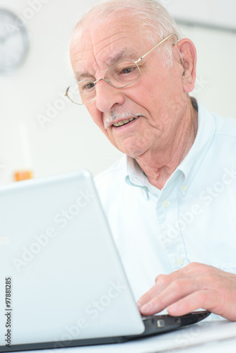 Elderly gentleman using a laptop