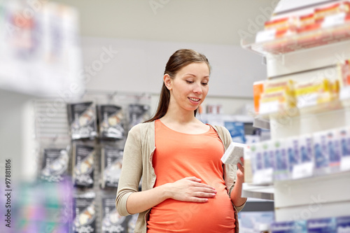 happy pregnant woman with medication at pharmacy