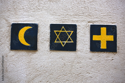 Set of 3 religious symbols: islamic crescent, jewish David's star, christian cross (wall sign on the street of Segovia, Spain)  photo
