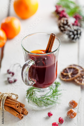 Mulled wine with fruits and spices on snow covered table.
