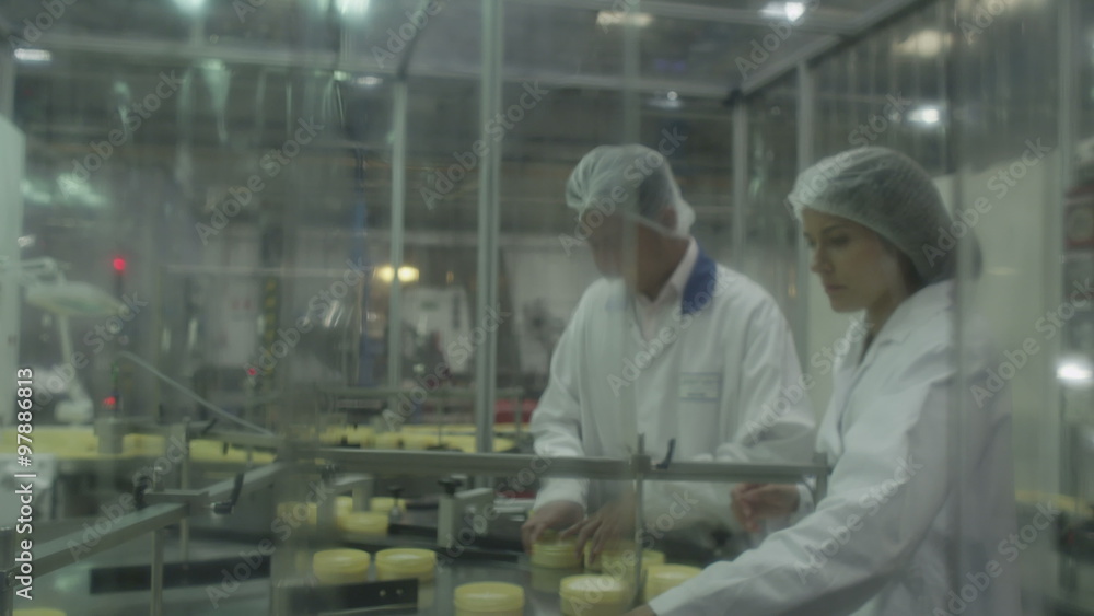 Quality control workers in pharmaceutical factory inspect medical or cosmetic containers on production line. Manufacturing business industry and cosmetic packaging firm Quality control workers in pharmaceutical factory inspect medical or cosmetic containers on production line. Manufacturing business industry and cosmetic packaging firm