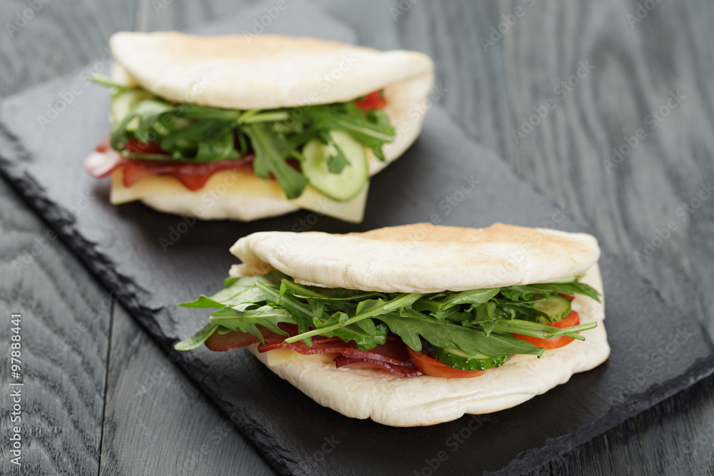 rustic sandwiches with ham arugula and tomatoes in pita bread rustic sandwiches with ham arugula and tomatoes in pita bread