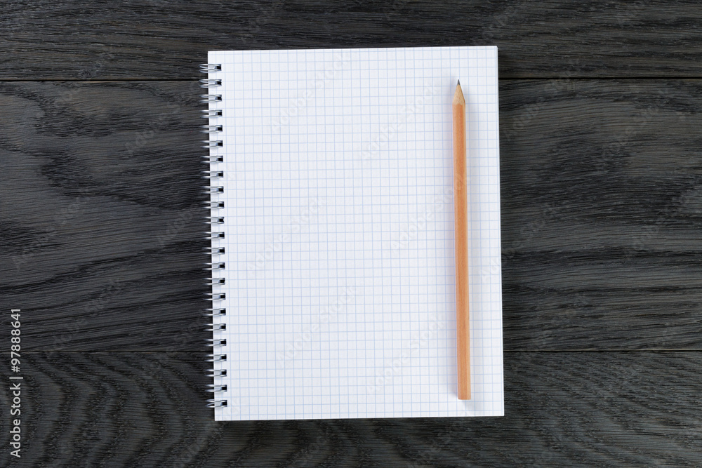 blank notepad with chequered pages on gray wood table with pencil blank notepad with chequered pages on gray wood table with pencil