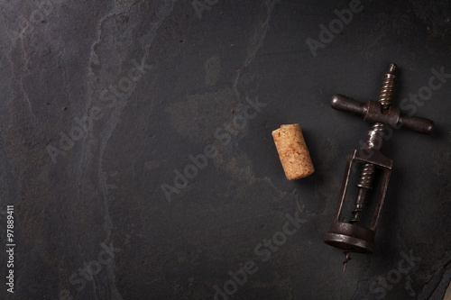 Vintage corkscrew and cork on stone table photo