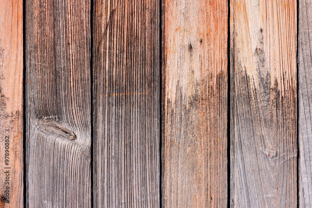 Naklejka premium Teak wood texture background. Wooden door composed of vertical teak planks with tongue and groove joints. After years in exposed condition the planks shown interesting texture.