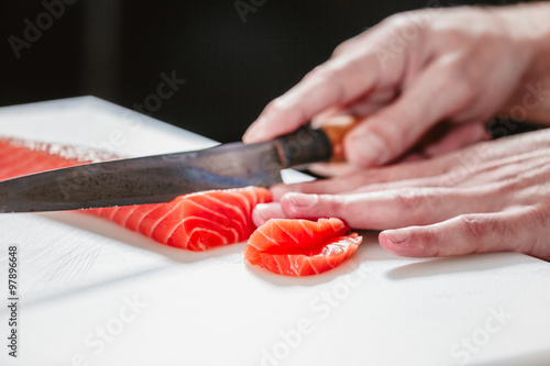 Cook cutting salmon