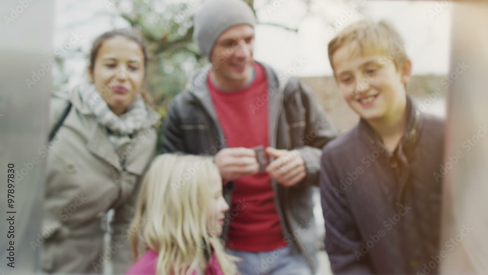 Cheerful family group withdrawing money from an ATM machine Cheerful family group withdrawing money from an ATM machine
