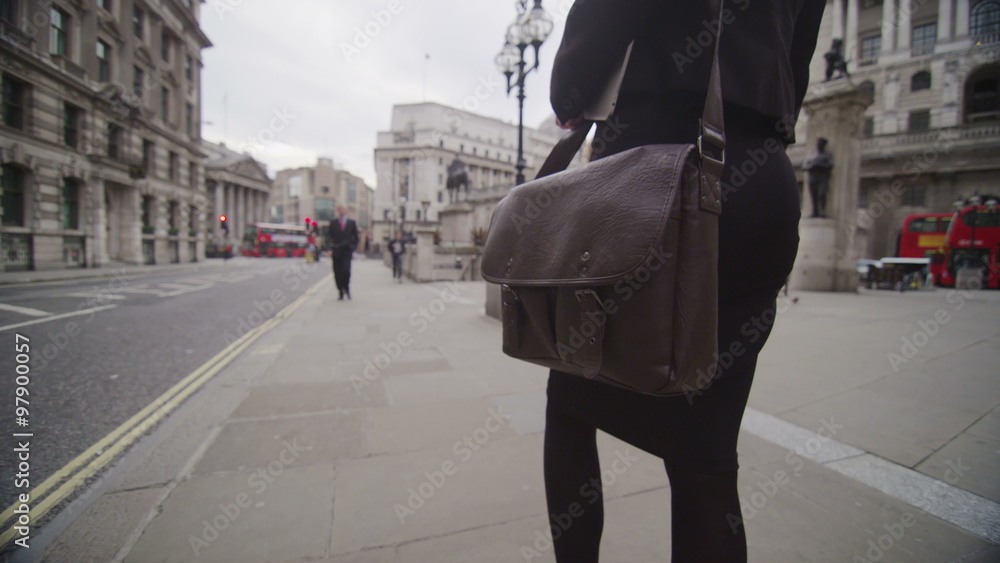 Business woman walking through the streets of London with briefcase Business woman walking through the streets of London with briefcase