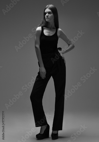high fashion portrait of young elegant woman in black pants shoe