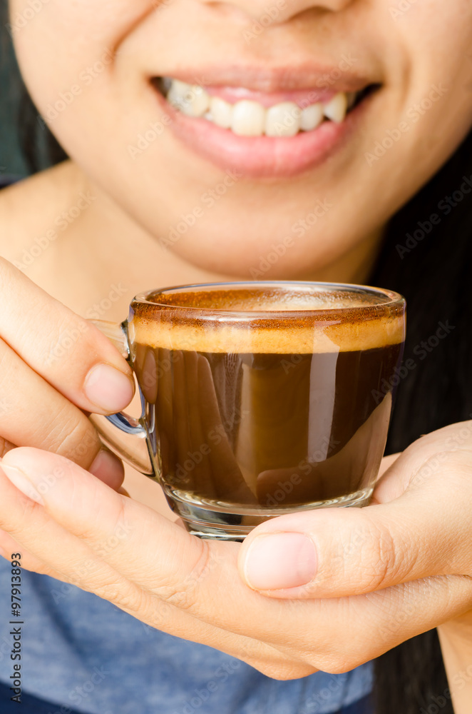 The cup of hot coffee (espresso) hold by woman hand The cup of hot coffee (espresso) hold by woman hand