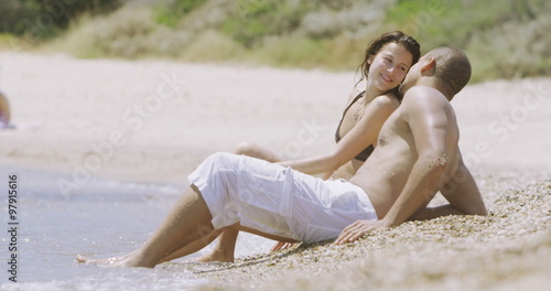  Happy attractive couple relaxing together at the beach. 