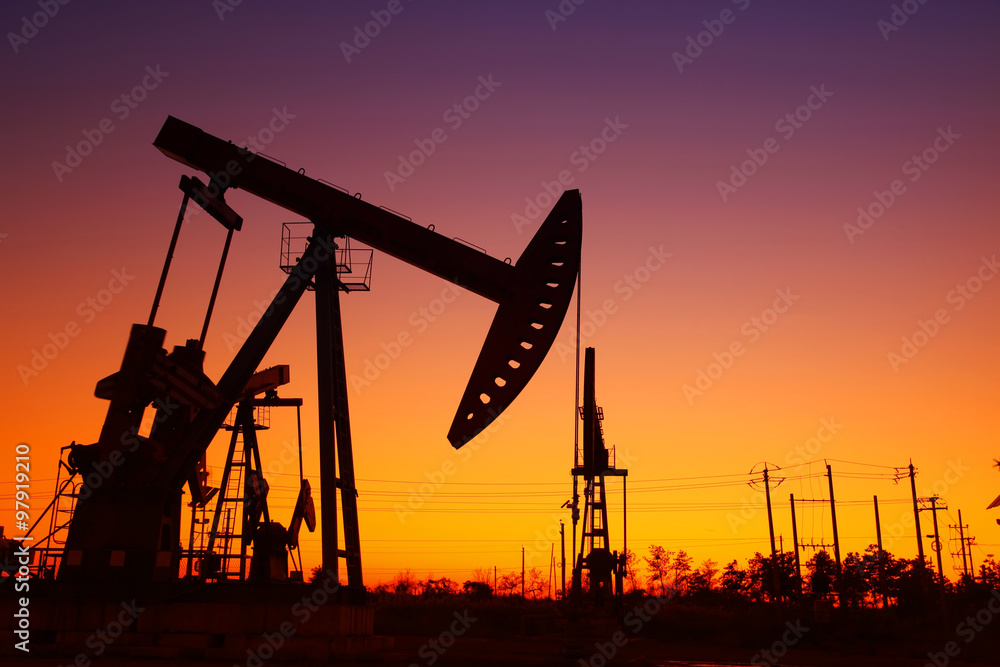 Oil field scene, the evening of beam pumping unit in silhouette Oil field scene, the evening of beam pumping unit in silhouette