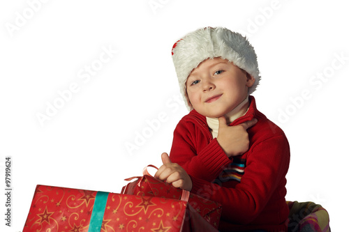 Handsome young boy in Santa's red hat holding a gift box