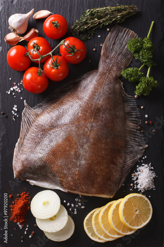 Obraz na plátne raw flounder with ingredients on a black board closeup