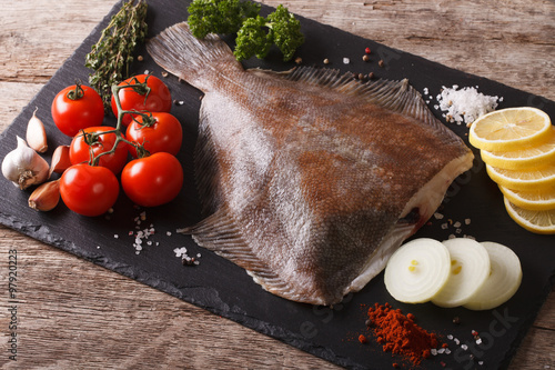 Slika na platnu Fresh raw plaice with ingredients on a slate board. horizontal