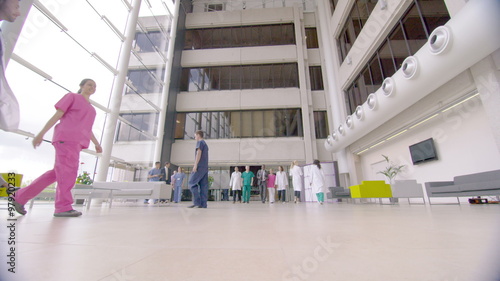  Mature group of medical professionals talking as they walk through hospital