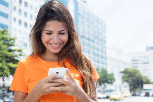 Junge Frau in der Stadt surft mit dem Handy photo
