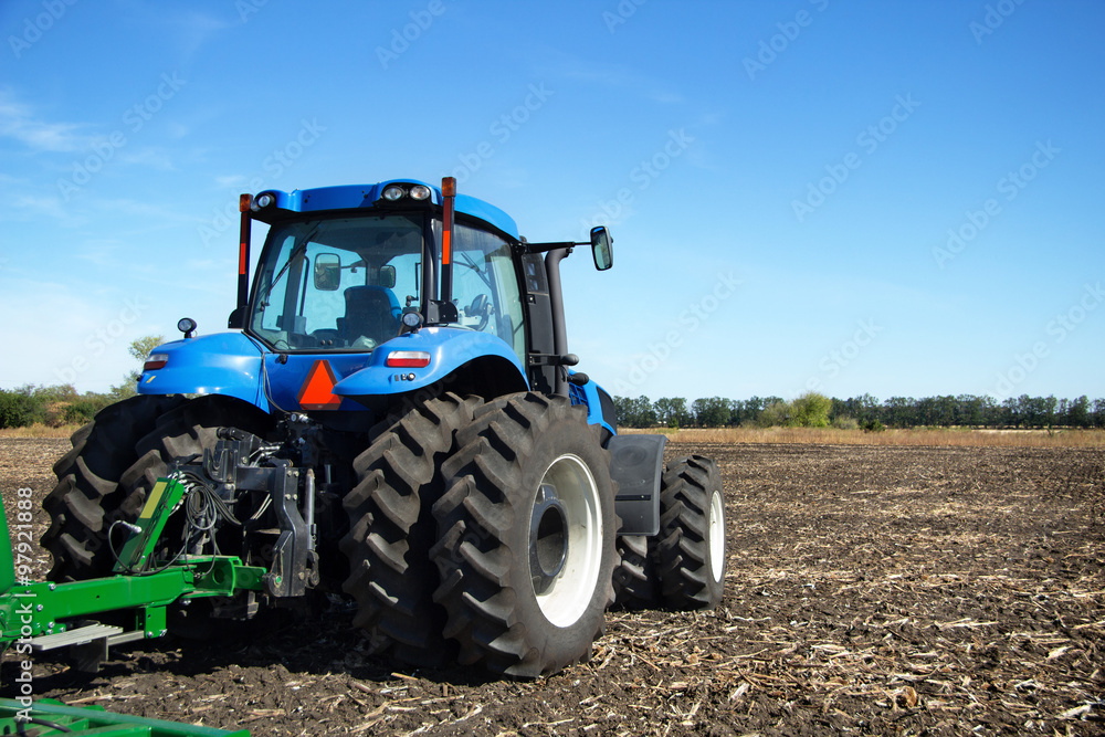 Fototapeta Tractor with plow working in the field