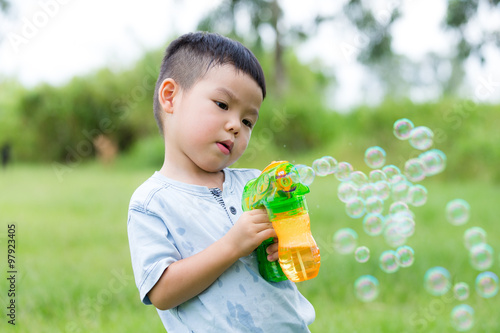 Little kid play with the bubble blower gun