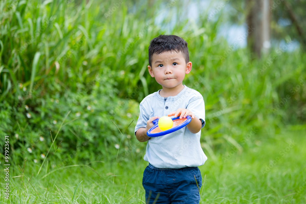 Asian kid playing tennis ball at park Asian kid playing tennis ball at park