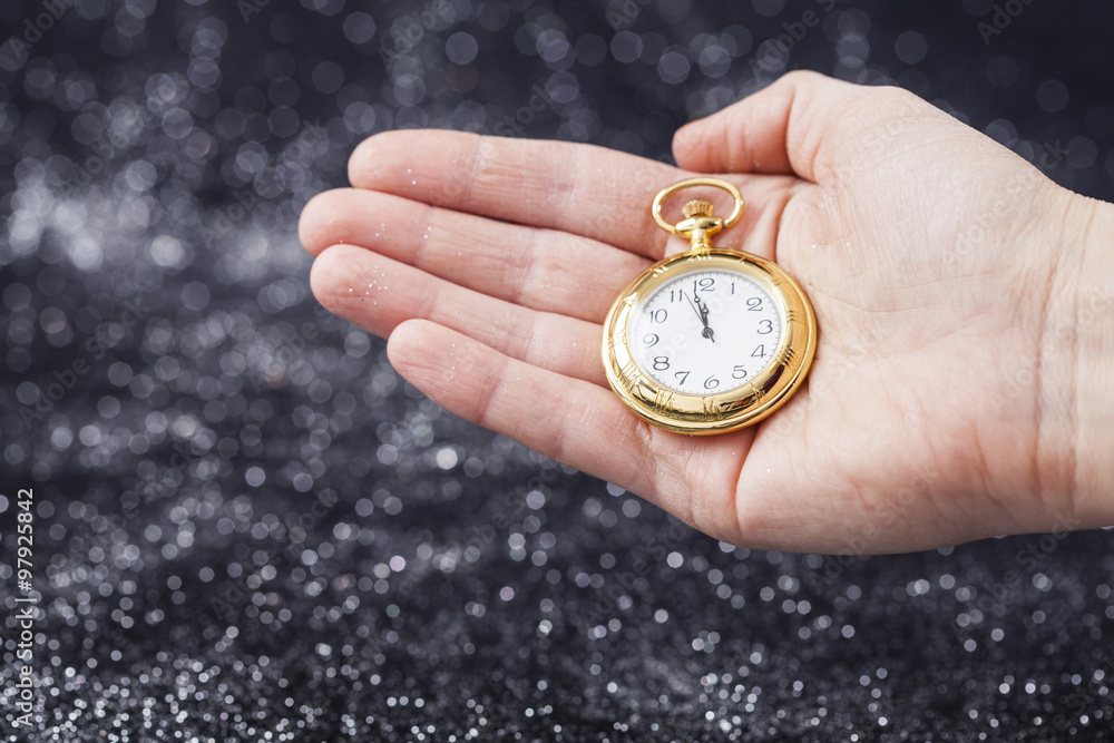 Hand holding old watch pointing midnight Hand holding old watch pointing midnight
