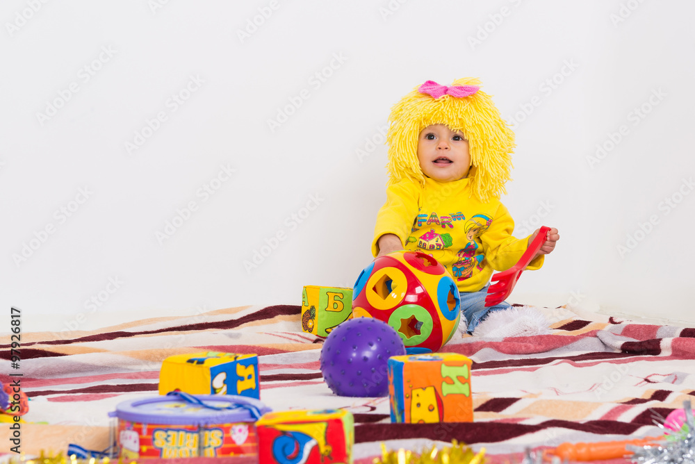 Little girl in a wig playing with toys