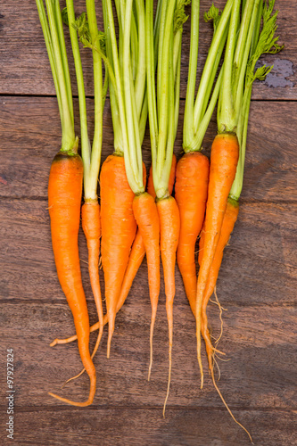 Bunch of baby carrots isolated on wooden background