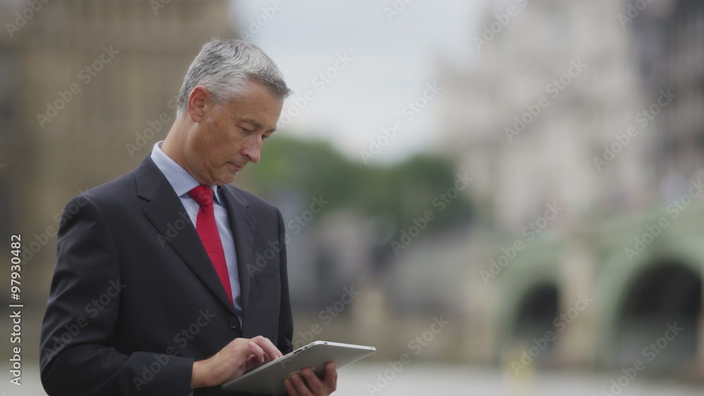 Businessman working on tablet computer outside Businessman working on tablet computer outside