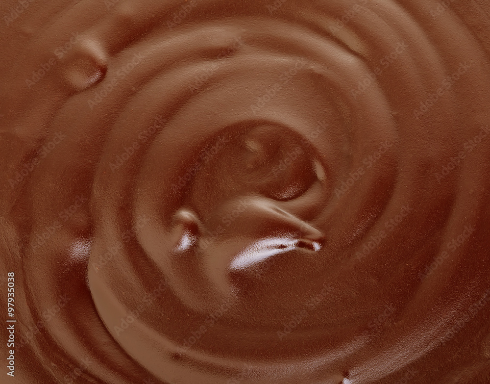 Melted dark chocolate flow, candy or chocolate preparation close-up as a background. Melted dark chocolate flow, candy or chocolate preparation close-up as a background.