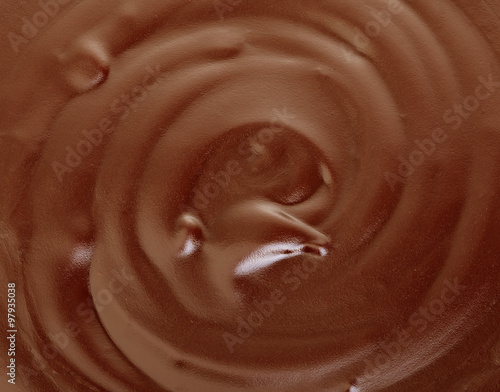 Melted dark chocolate flow, candy or chocolate preparation close-up as a background.