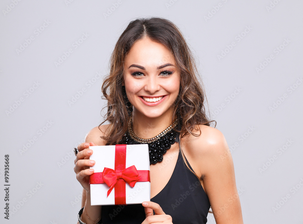 Young woman happy smile hold gift box in hands, isolated over grey background Young woman happy smile hold gift box in hands, isolated over grey background