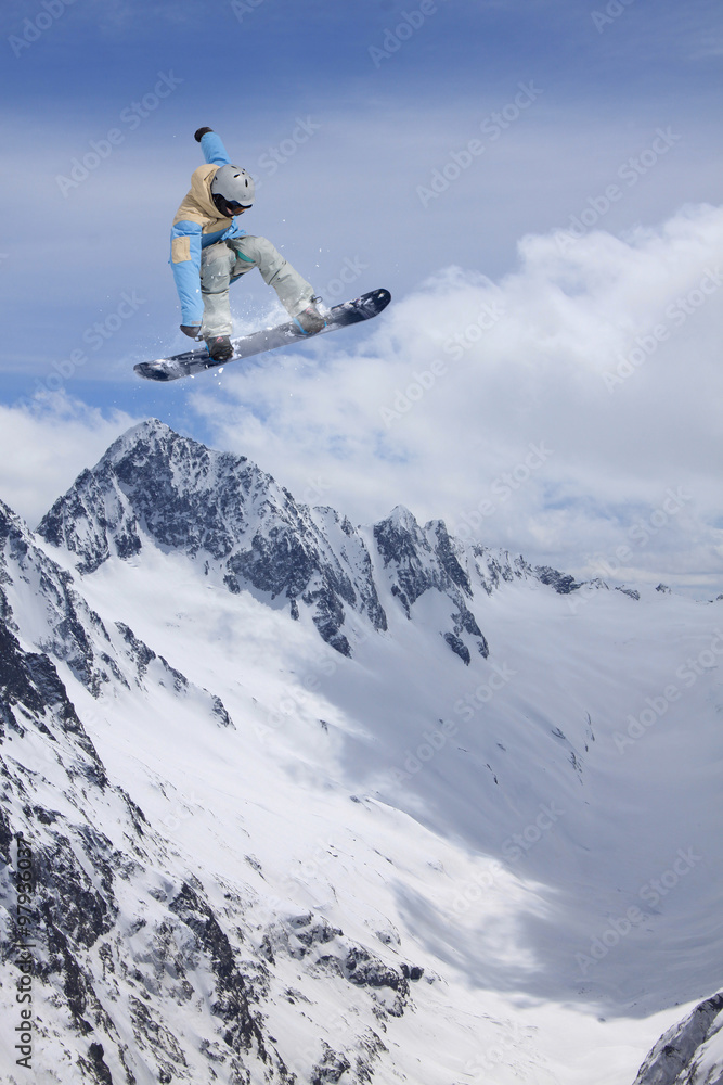 Flying snowboarder on mountains. Extreme sport.