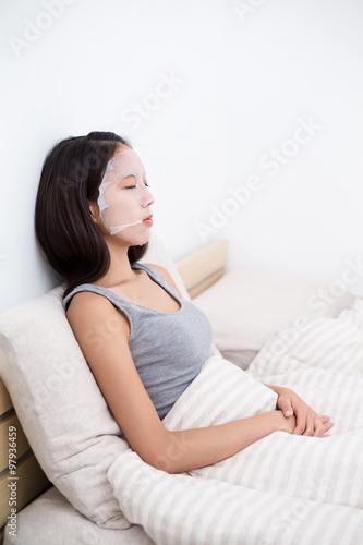 Asian Woman lay down and doing facial mask