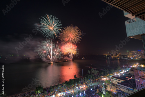 Group of people enjoying spectacular fireworks show in a carnival or holiday.