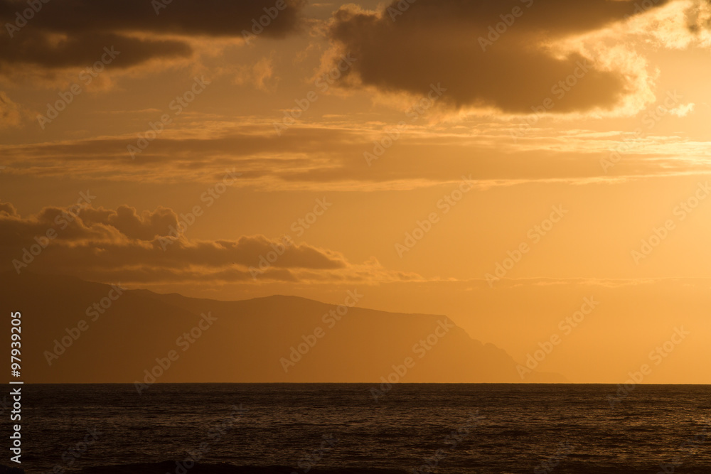 Sunset over the ocean colored sky in sepia.